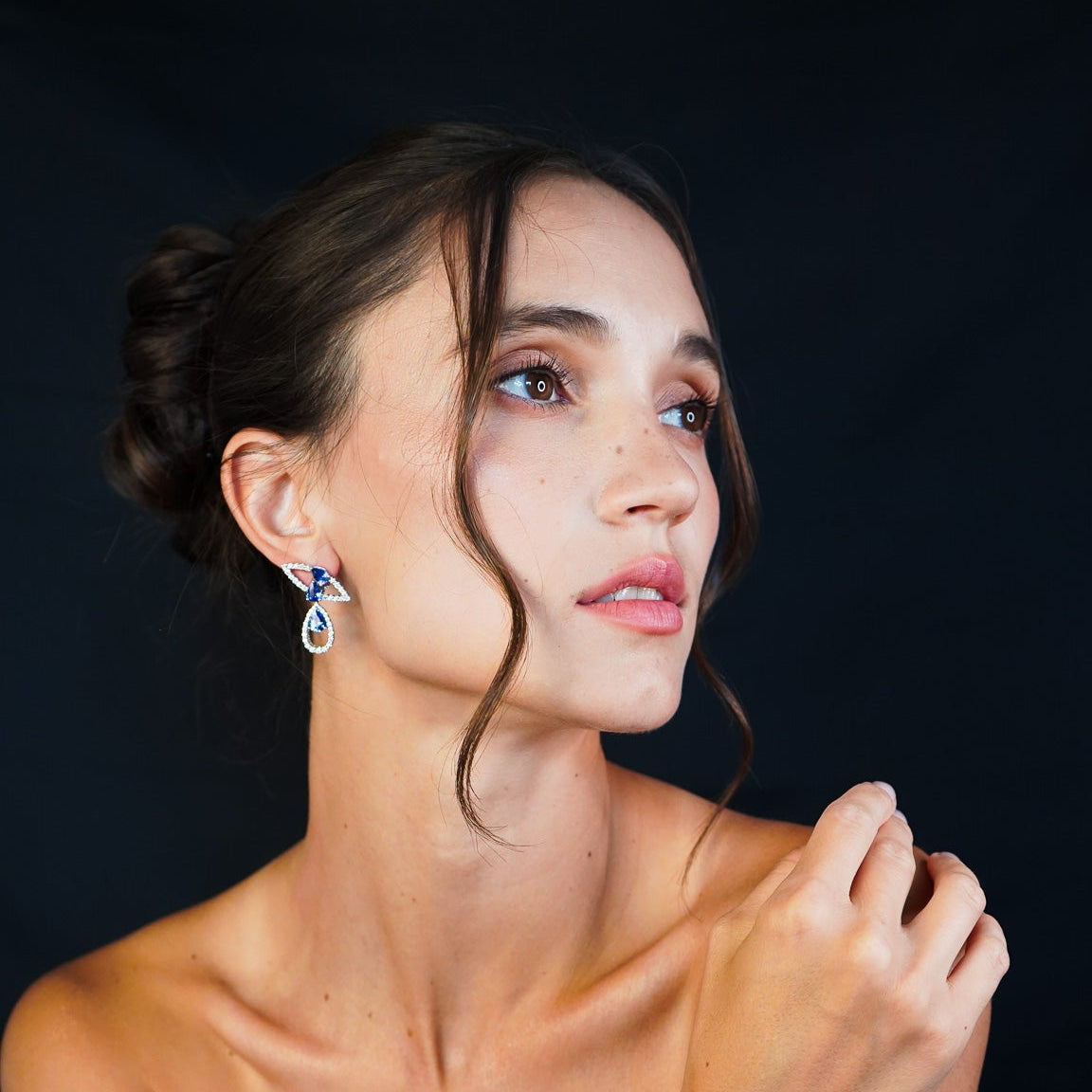 Woman wearing Tear drop sapphire ring with diamonds in fine gold by Inara Fine Jewellery