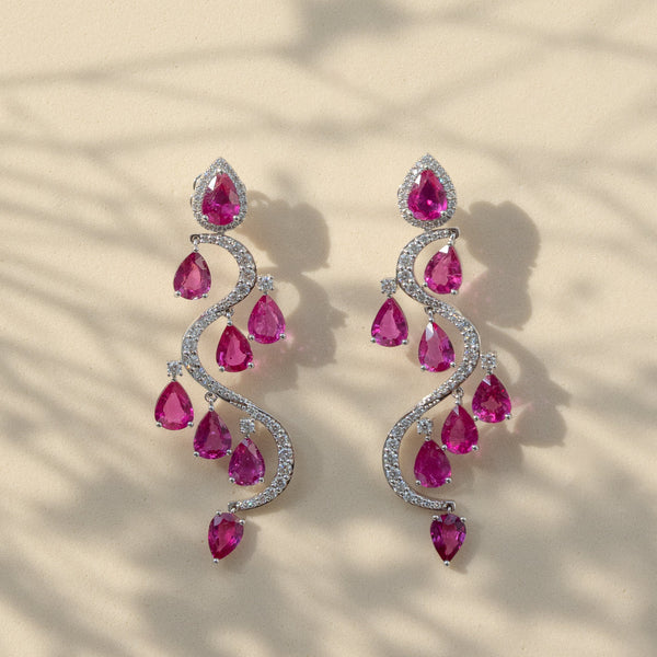 Elegant earrings with pink gemstones on a beige background