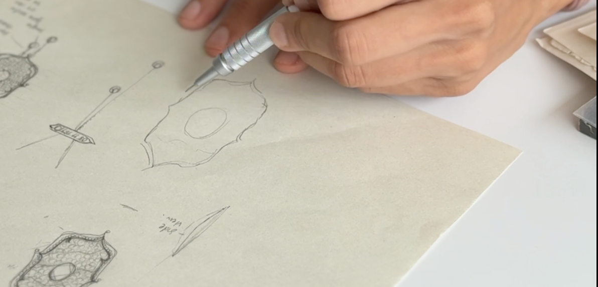 Person drawing technical sketches on paper with a pen